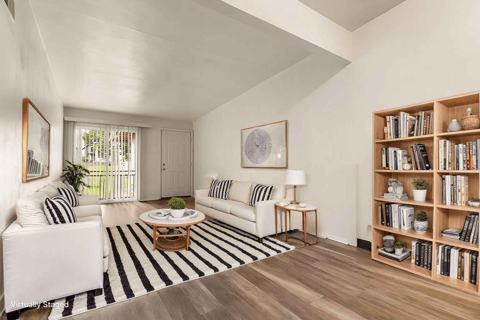 A living room with a white couch, a coffee table, and a bookshelf.